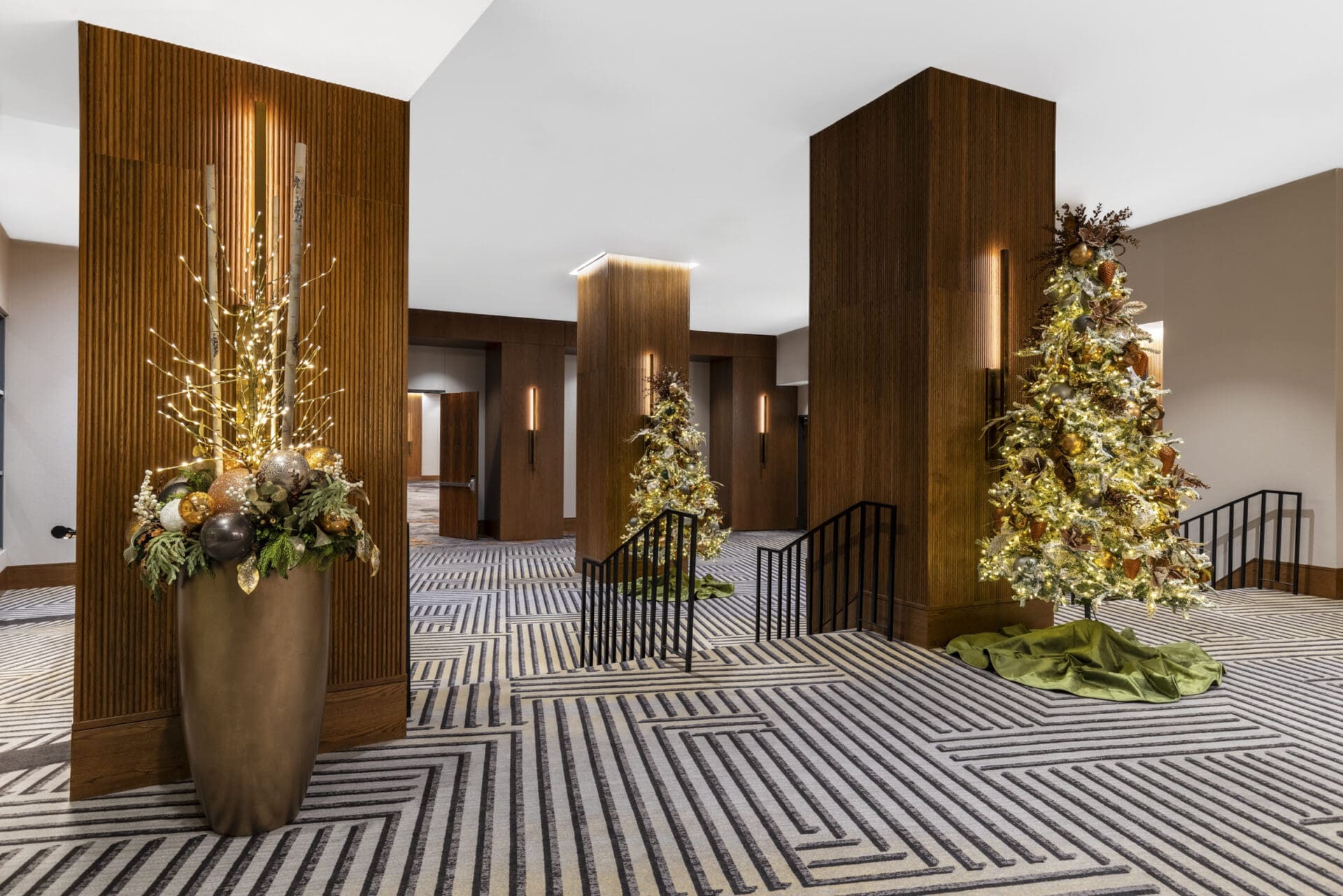 Hilton_8 Frosted Christmas trees with warm lights installed between elegant wooden pillars at the Hilton Lincoln Centre by a commercial Christmas decorator Dallas.